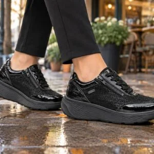 G-Comfort S-2725SF fekete lakk női sneaker lábon G-Comfort S-2725SF fekete lakk női sneaker lábon, őszi utcán kávézó előtt